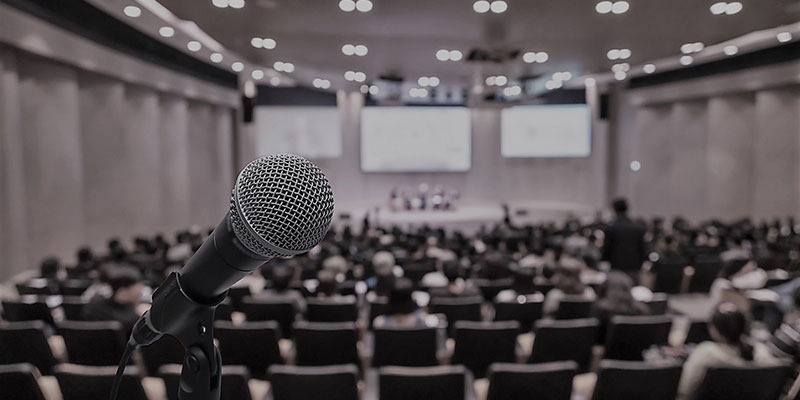 Salle de conférence et micro au premier plan