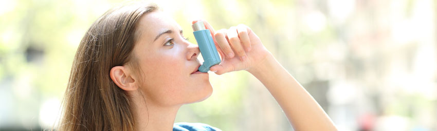 Jeune femme utilisant un dispositif pour soulager son asthme